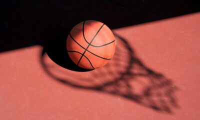 Un pallone di basket e sullo sfondo l'ombra di una retina da canestro