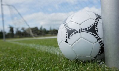 Un pallone in primo piano sull'erba di un campo di calcio