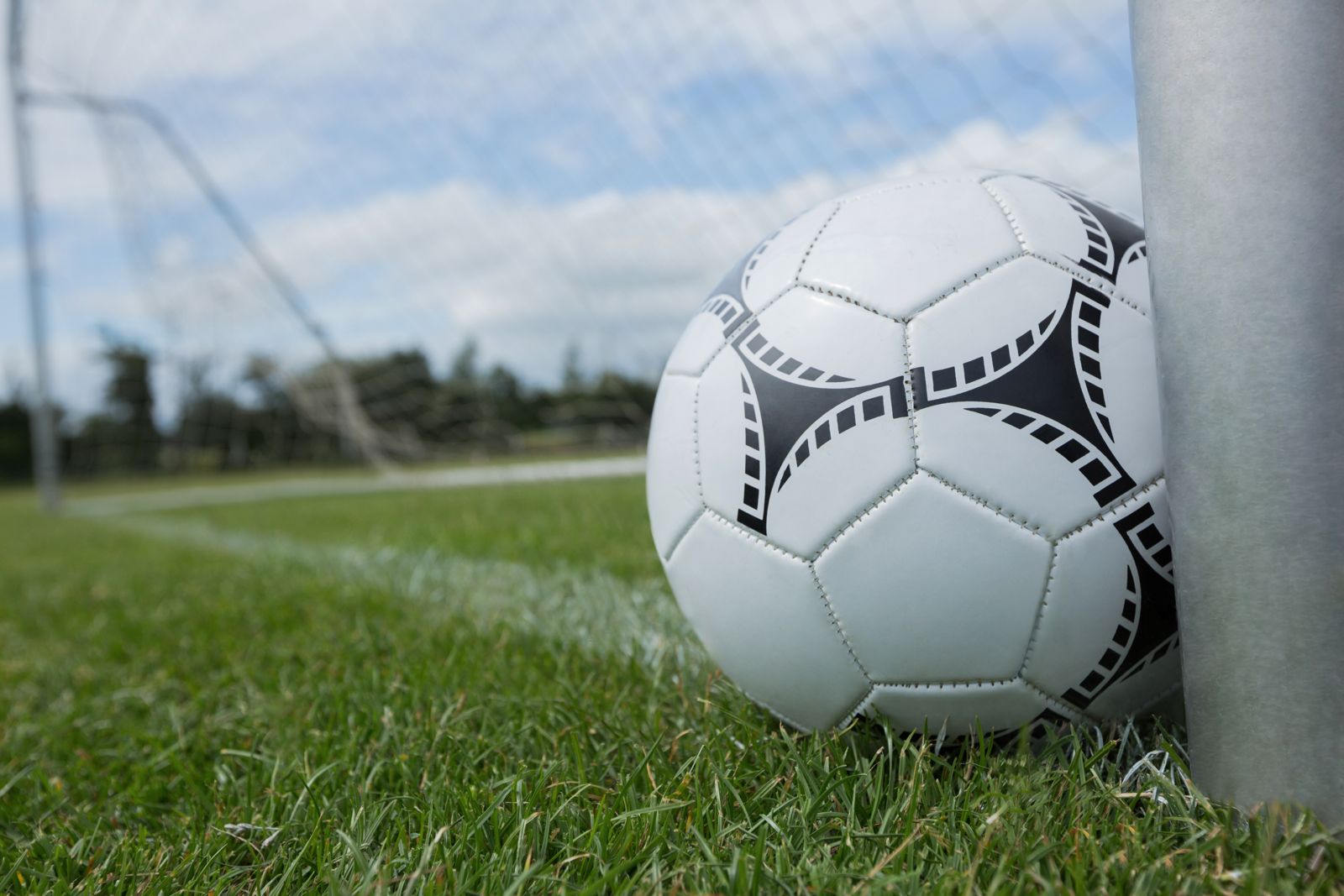 Un pallone in primo piano sull'erba di un campo di calcio