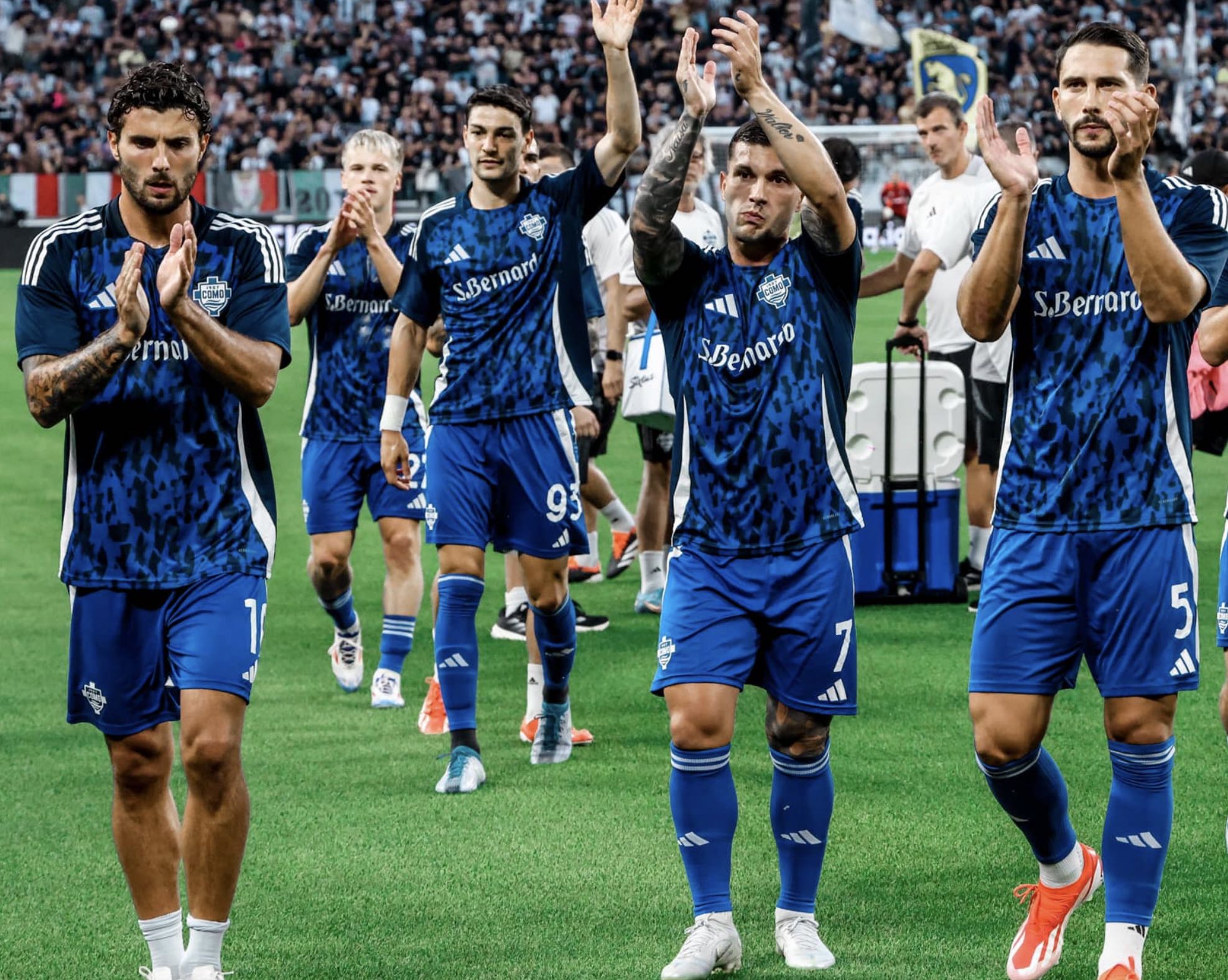 Primo piano dei giocatori del Como che salutano i propri tifosi