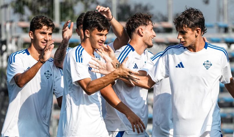 Dettaglio dei giovani calciatori del Como Primavera mentre festeggiano dopo un goal.